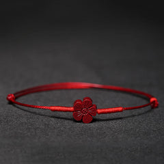 Cinnabar PiXiu Lotus Koi Fish Blessing Braid Bracelet – red cinnabar flower charm on red cord against black background, handmade lucky jewelry