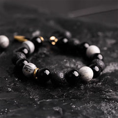 Black Obsidian Lava Rock Bracelet – Low angle shot of polished onyx and howlite beaded stretch bracelet