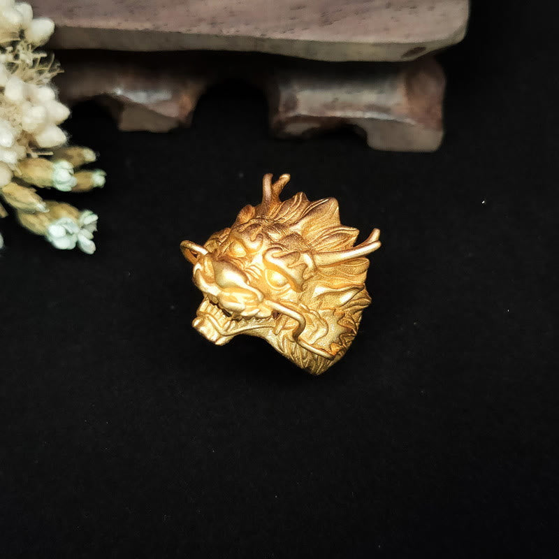 Golden Dragon Luck Protection Ring – frontal dragon face with bold horns and artisan wooden display stand