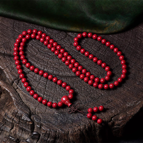 108 Mala Beads Cinnabar Bracelet – Overhead view on tree stump, red prayer necklace