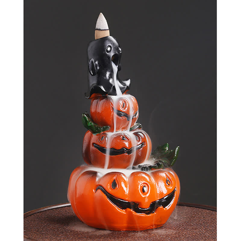 Three-quarter view of Halloween pumpkin ghost burner, cascading smoke through three jack-o-lanterns, glossy orange ceramic – backflow incense burner