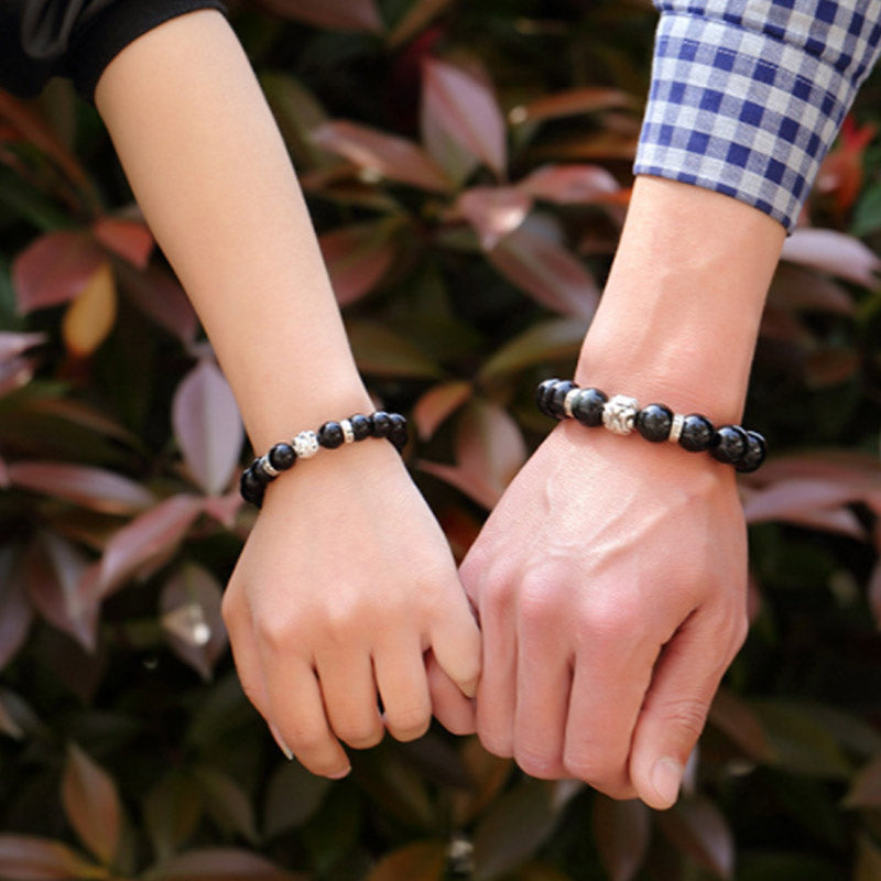 Rainbow Obsidian Bracelet – Couple wearing bracelets holding hands outdoors with plants, love gift