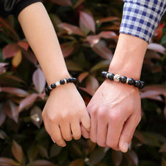 Rainbow Obsidian Bracelet – Couple wearing bracelets holding hands outdoors with plants, love gift