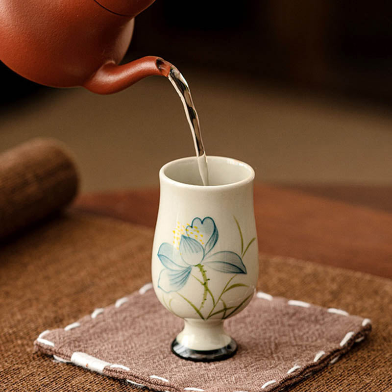 Hand Painted Lotus Tea Cup – bowl cup with amber tea and stemmed cup behind, lotus decoration, pair display