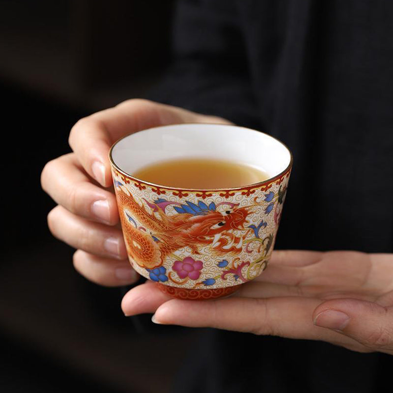 2Pcs Dragon Phoenix Ceramic Teacup Set - Orange dragon cup held with red border detail, imperial