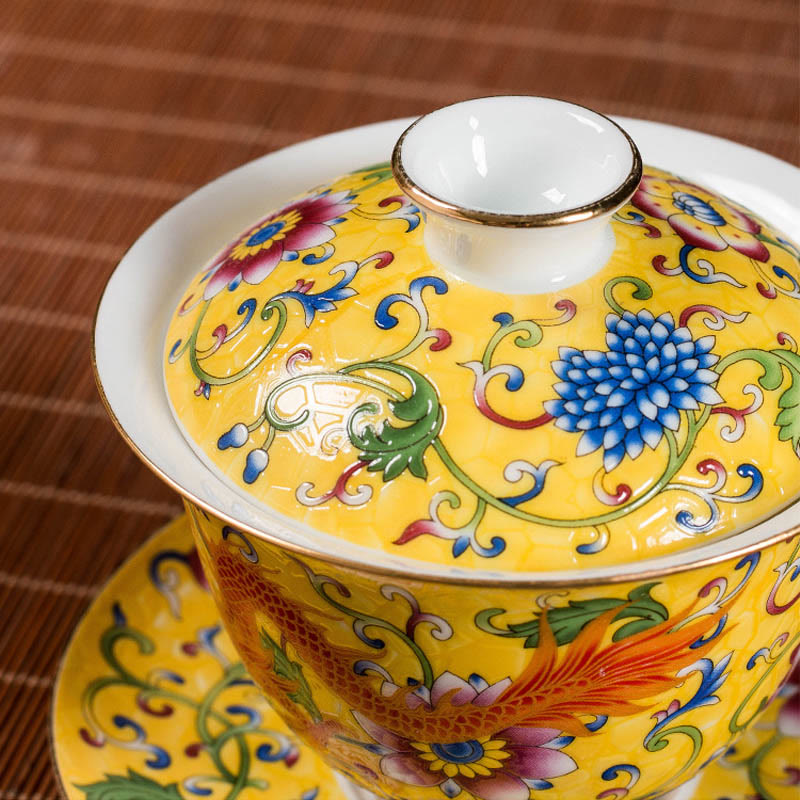 Dragon Phoenix Flower Gaiwan Tea Set – Yellow gaiwan lid close-up with chrysanthemum scrollwork on bamboo mat