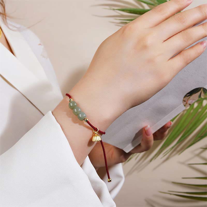 Hetian Jade Lotus Pod Braided Bracelet – worn on wrist with natural foliage, elegant lifestyle