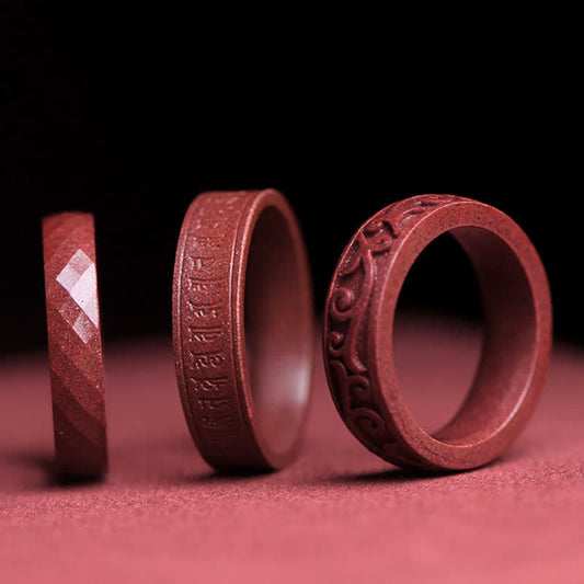 Cinnabar Om Mani Padme Hum Blessing Ring – three vermilion cinnabar rings with carved mantra, facets and cloud motifs, dark studio background