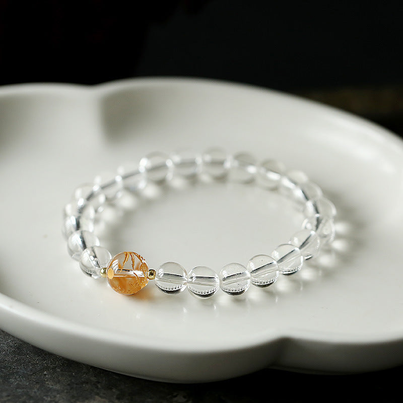 Black Obsidian White Crystal Onyx Dragon Bracelet - Clear crystal bracelet with golden focal bead on dark surface, Strength