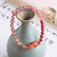 Strawberry Quartz Koi Bracelet – close-up of carved cinnabar koi fish bead with fine scale detail