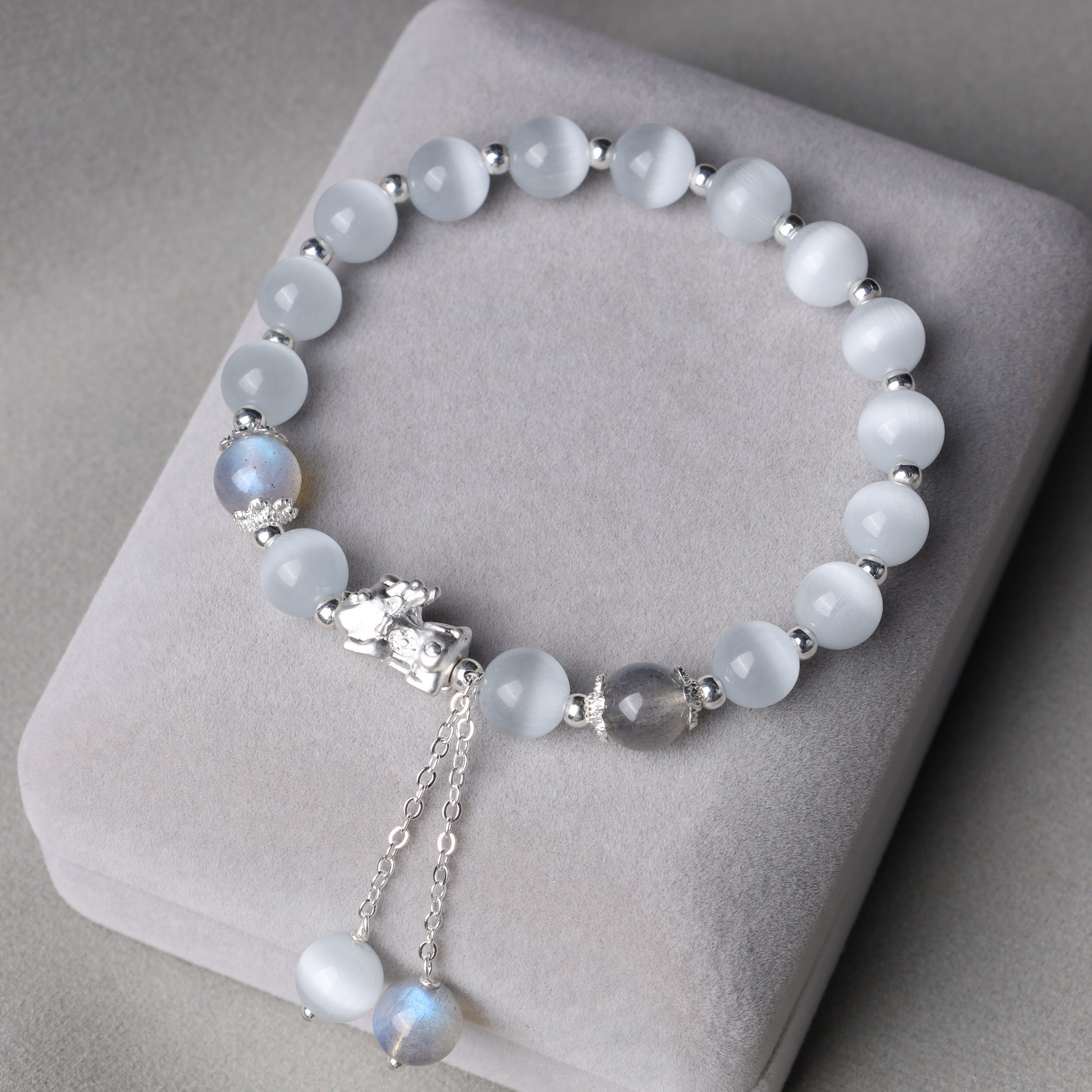 Cat's Eye PiXiu Bracelet – Gray cushion display with cat's eye moonstone beads and silver accents