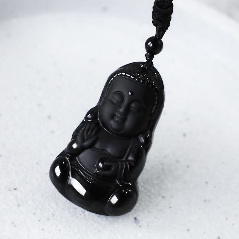 Black Obsidian Buddha Closeup - angled 3/4 view of polished black stone carving with hair texture detail, Calming