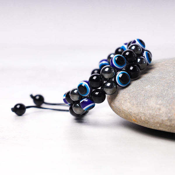 Evil Eye Tiger Eye Bracelet – multi-strand hematite black and evil eye beads on river stone display