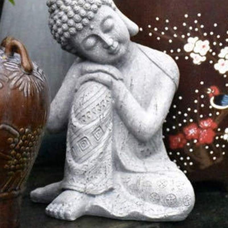 Tibetan Meditation Buddha Resin Decoration – resting Buddha beside floral ceramic vase in garden corner, textured resin craft, mindfulness gift