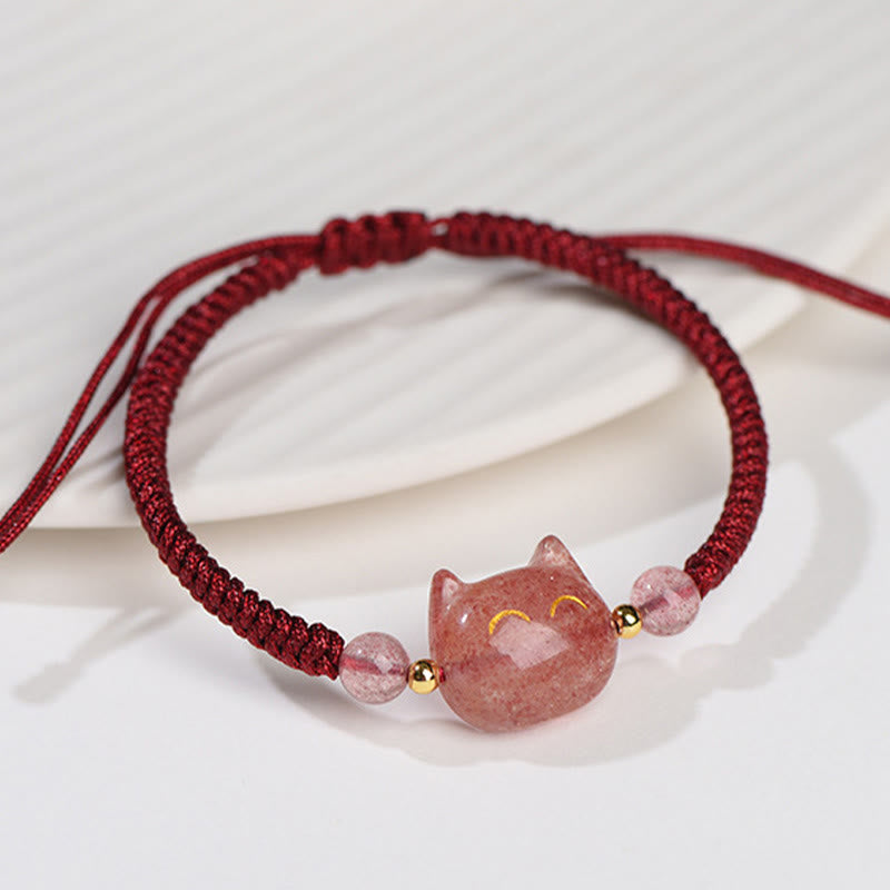 Handcrafted adjustable bracelet with strawberry quartz cat charm, gold smile details, pink crystal beads and burgundy macrame cord on white fabric
