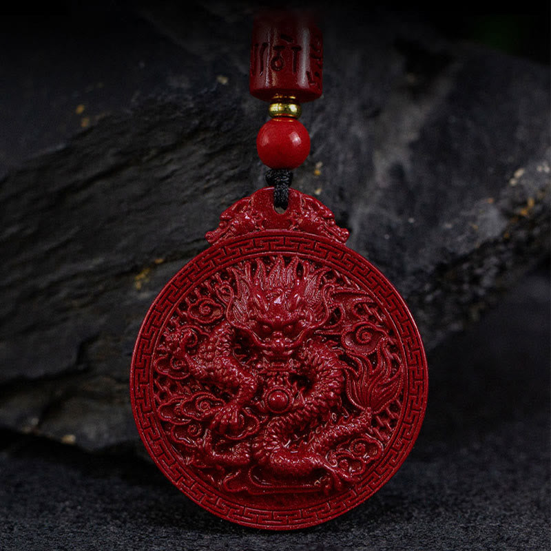 Cinnabar Dragon Pendant – Front-facing dragon relief with Greek key border on dark slate, Powerful