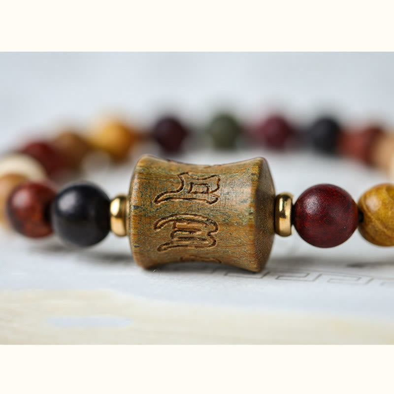 Multicolored Sandalwood Prayer Bracelet – Macro close-up of carved mantra center bead, wood grain