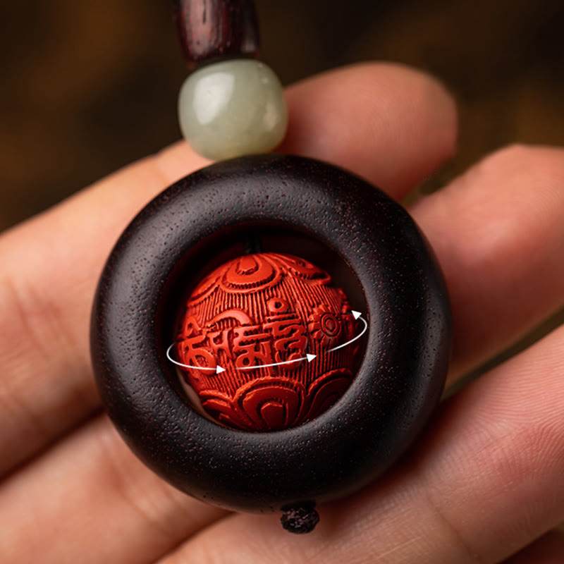 Tibetan Om Mani Padme Hum Sandalwood Cinnabar Protection Keychain – hand holding rotating cinnabar bead detail, spiritual accessory
