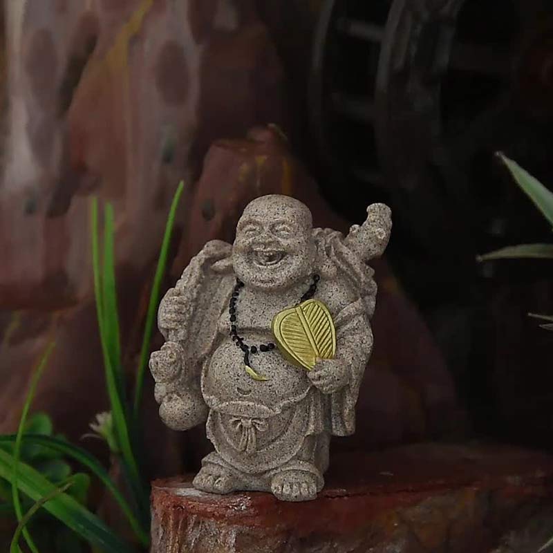 Laughing Buddha Resin Statue - stone Buddha with gold fan in garden setting, natural ambiance, Grounding
