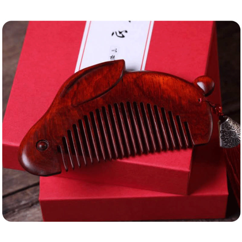 Red sandalwood bunny comb displayed on top of red gift boxes