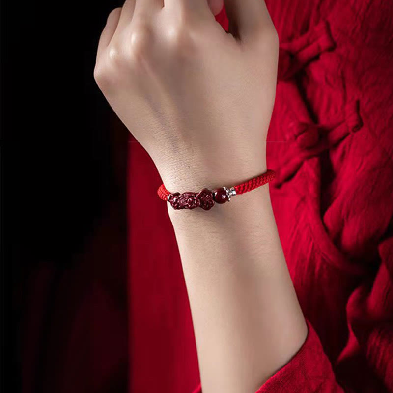 Handcrafted PiXiu Cinnabar Wealth Luck Braided Bracelet – wrist model with red cloth backdrop, elegant wear