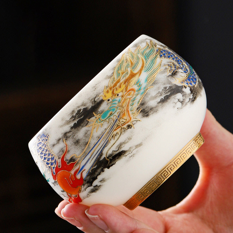 Dragon Playing Pearl Porcelain Teacup – Gold dragon with red pearl amid black ink clouds, hand-held tactile luxury