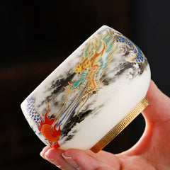 Dragon Playing Pearl Porcelain Teacup – Gold dragon with red pearl amid black ink clouds, hand-held tactile luxury