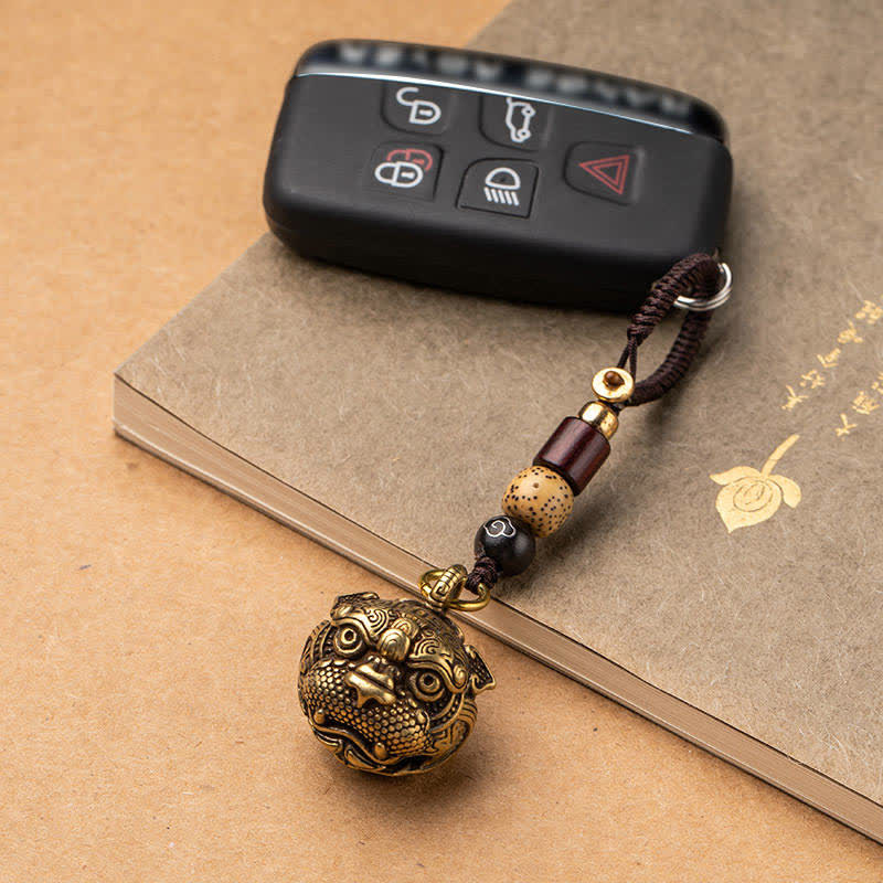 Pixiu Wealth Copper Key Chain – attached to car key practical use display on book background, lucky prosperity keychain