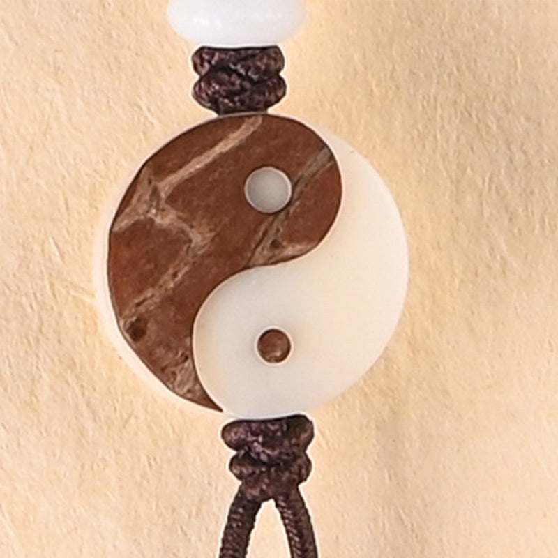 Ebony Yin Yang Protection Mala - carved yin-yang pendant on knotted cord close-up, meditation charm