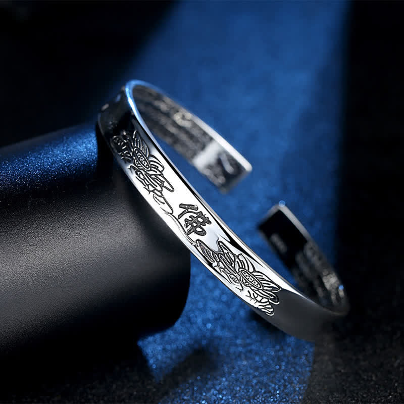 Heart Sutra Lotus Copper Cuff Bracelet - silver open bangle on black stand with blue backdrop, Mindful accessory