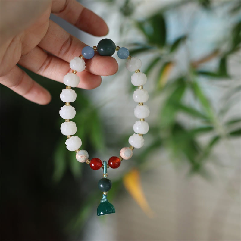 Carved Bodhi Seed Lotus Bead Peace Bracelet - held in hand with green charm, serenity