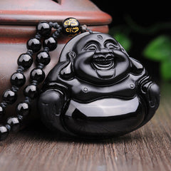 Black Obsidian Laughing Buddha Pendant – side angle with beaded necklace on wooden table, protection and strength