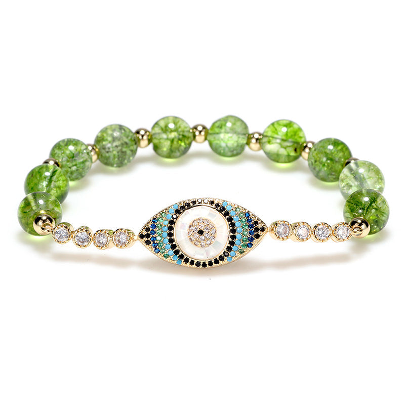 Green peridot bead bracelet with gold evil eye pave crystal center on white background