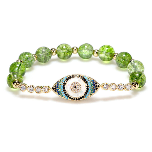 Green peridot bead bracelet with gold evil eye pave crystal center on white background