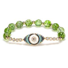 Green peridot bead bracelet with gold evil eye pave crystal center on white background