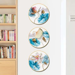 Lotus Wall Art – Vertical arrangement of three circular canvases beside wooden bookshelf, blue watercolor leaves, calming