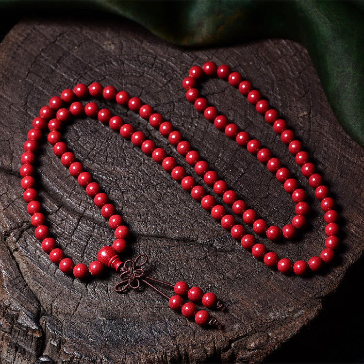 108 Mala Beads Cinnabar Bracelet – Flat lay on bark texture, 108 red carved beads