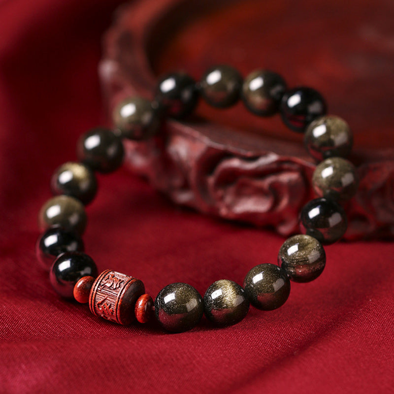 Gold Sheen & Rainbow Obsidian Fu Bracelet – low-angle view on red fabric, gold-sheen obsidian detail