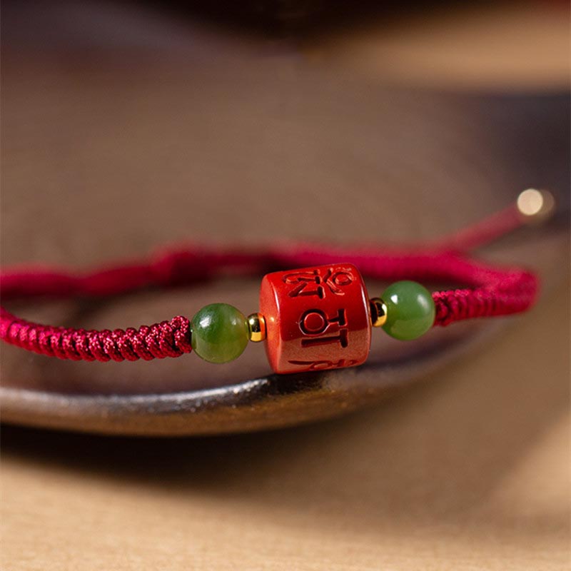 Tibetan Cinnabar Braided Rope Bracelet – Close-up side angle of carved cinnabar bead with green jade stones