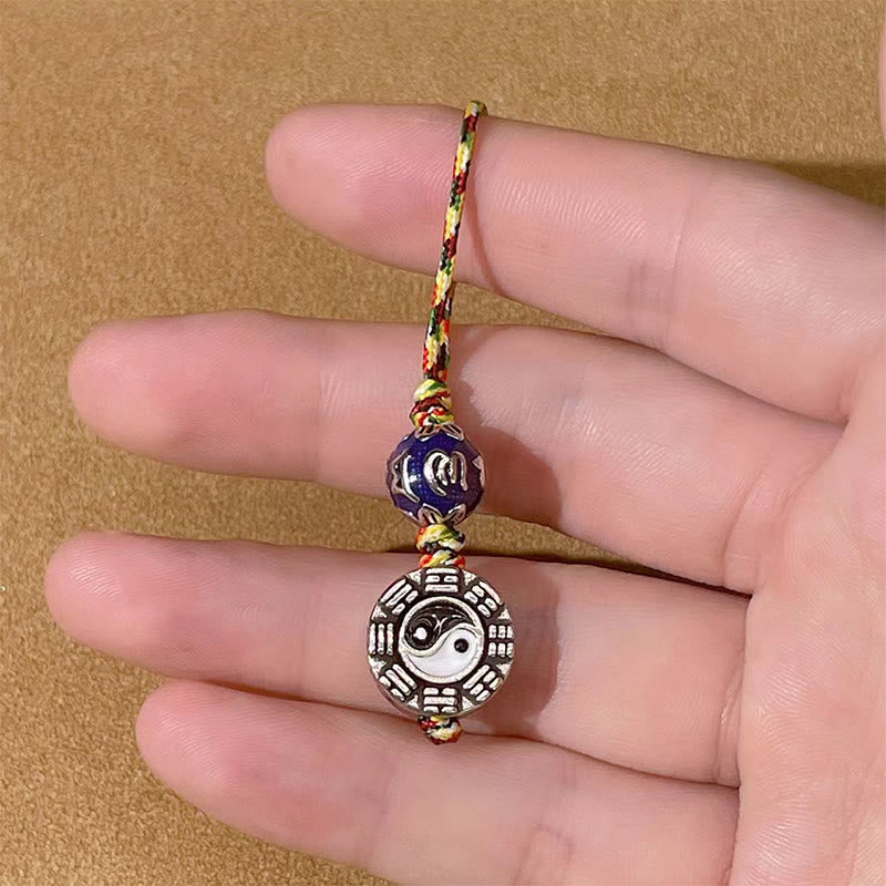 Yin Yang Bagua Keychain – Held in hand for scale reference, copper bagua medallion with blue enamel bead visible