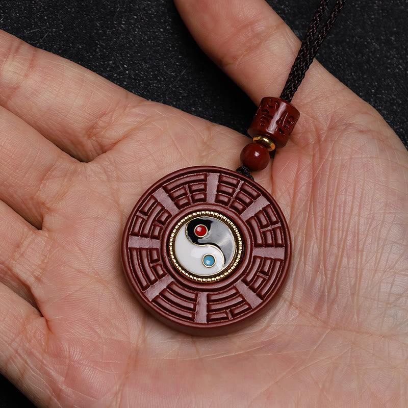 Cinnabar Bagua Rotatable Yin Yang Necklace – Cinnabar Bagua pendant in palm, scale reference, spiritual gift jewelry