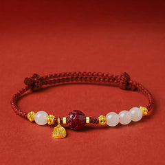 24K Gold Jade Cinnabar Lotus Bracelet – Red braided cord with white jade beads, gold lotus spacers and carved cinnabar bead on red background