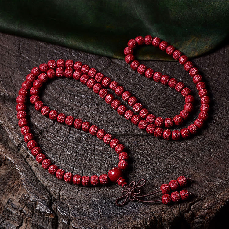 108 Mala Beads Cinnabar Bracelet – Flat lay on dark wood grain, red prayer beads