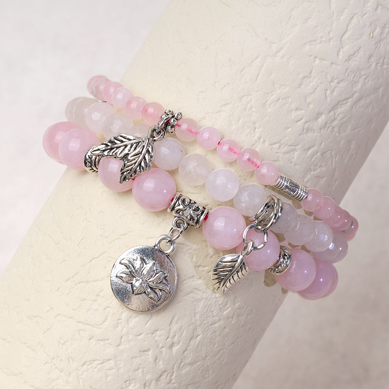 Crystal Lotus Bracelet – rose quartz and white opal beads layered on wrist stand with silver charms, stacking bracelet