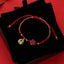 Red and gold braided Chinese fortune bracelet with cinnabar Fu blessing charm and carved flower pendant in velvet gift box