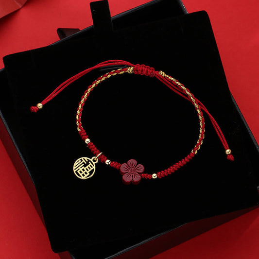 Red and gold braided Chinese fortune bracelet with cinnabar Fu blessing charm and carved flower pendant in velvet gift box