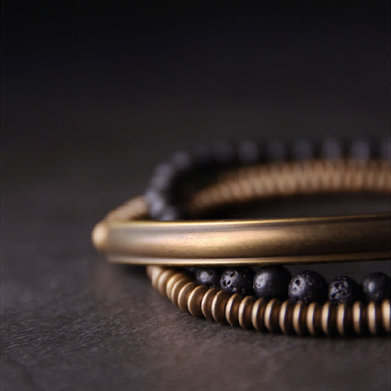 Lava Rock Copper Healing Bracelet – Black porous lava bead bracelet with copper center bead and silver spacers worn on wrist, soft blurred neutral background lifestyle