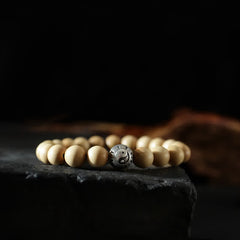 Peach Wood Yin Yang Bracelet – Yin yang metal bead on cream wood beads on dark stone, spiritual balance
