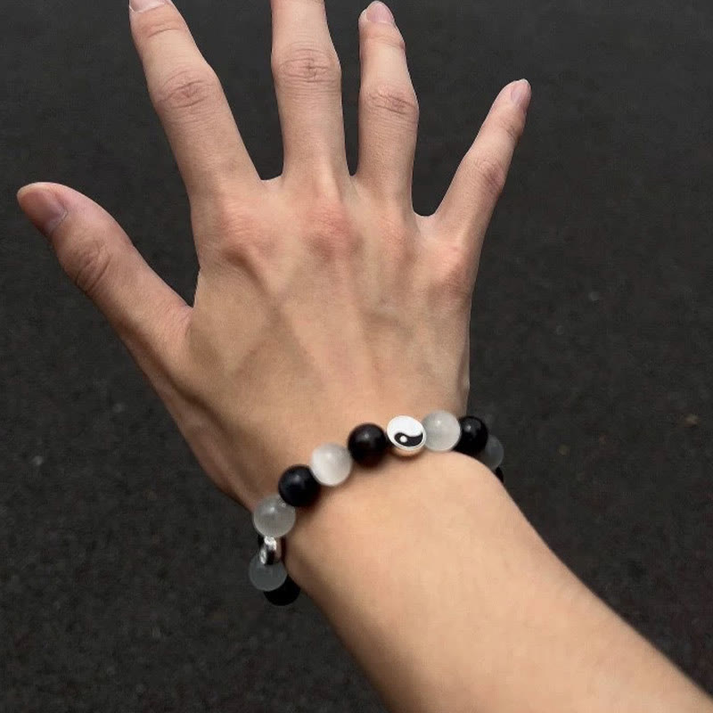 Black Obsidian Cat Eye Yin Yang Bracelet - worn on wrist with yin-yang center bead, obsidian cat's eye bracelet lifestyle shot