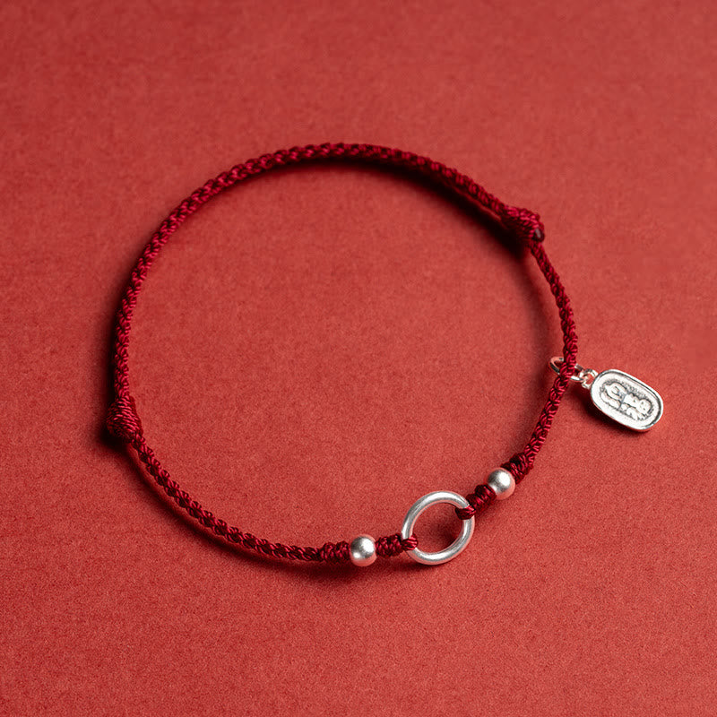 Sterling Silver Lotus Peace Buckle Red String Bracelet – Close-up of braided red cord with adjustable sliding knot and silver charms engraved with Chinese fortune characters in a circular vignette